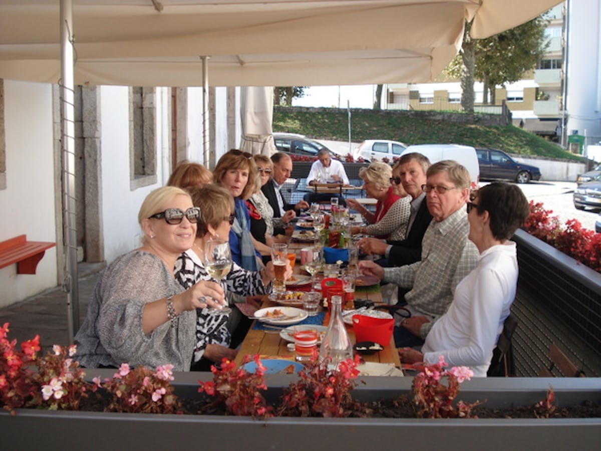 a group of people sitting at a table during braga food tour