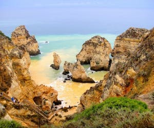 a rocky island in the middle of a body of water. algarve coast real estate