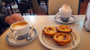 a cup of coffee and custard tarts in lisbon