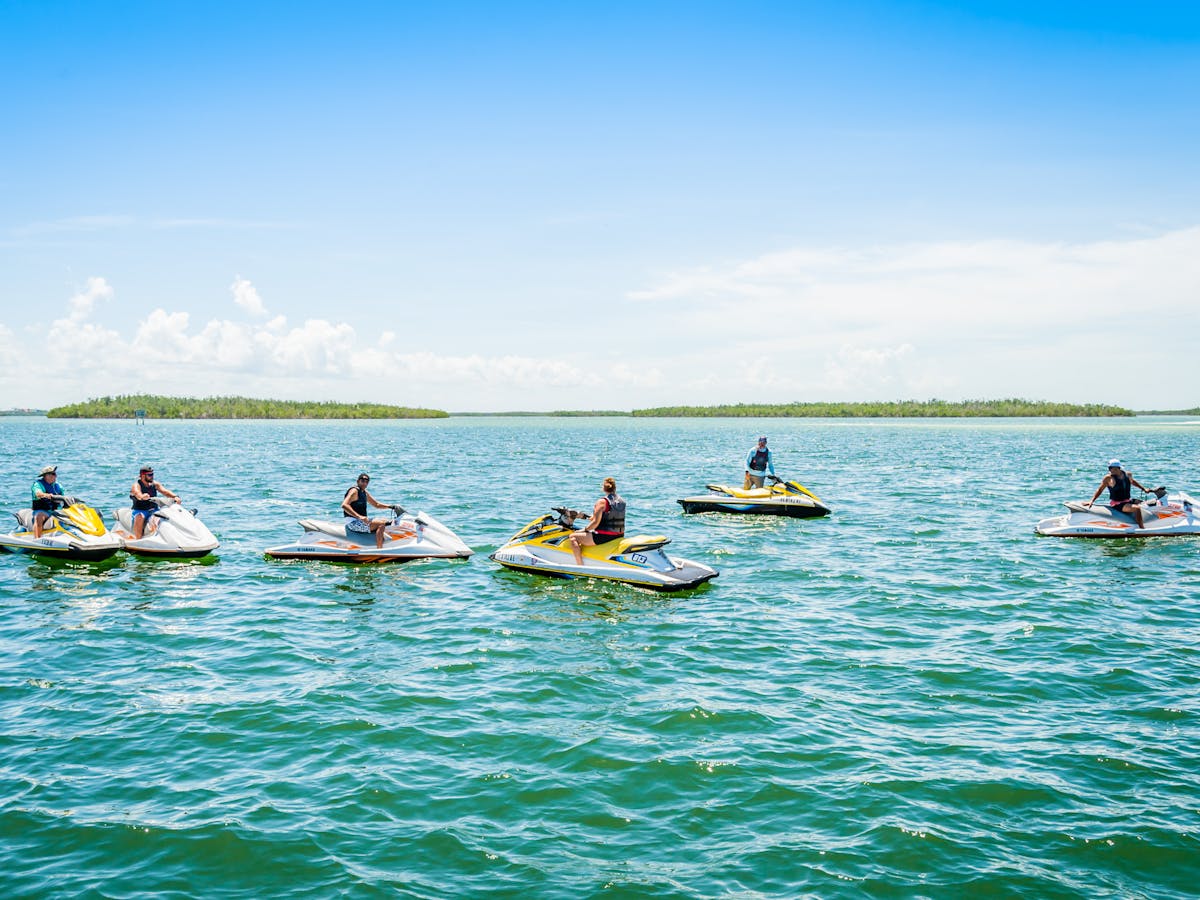 group of people sitting on jet skis during a jet ski tour