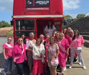 a group of people standing in front of a double decker bus