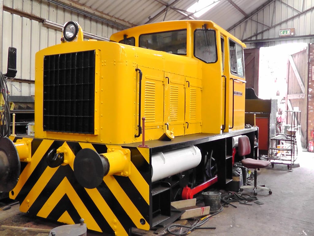 a yellow and black truck sitting on the train tracks