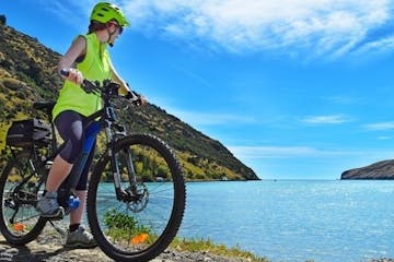 a bicycle next to a body of water with a mountain in the background
