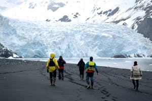 a group of people walking across a snow covered mountain