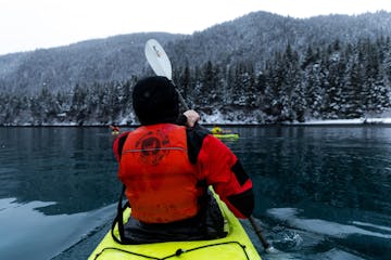 a man holding a snow board in the water