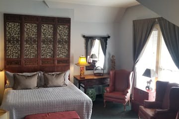 a bedroom with a bed and a chair in a room