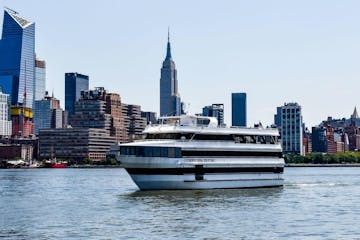 a large boat in a body of water with a city in the background