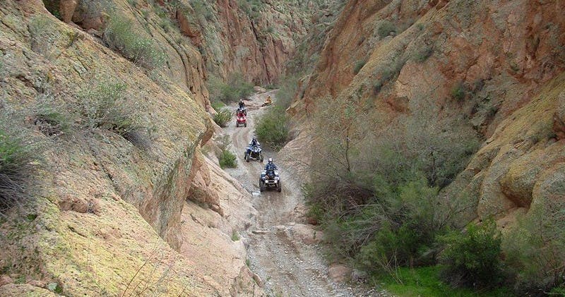 People riding on ATVs through Box Canyon in Arizona