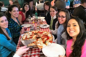 Rebecca Makkai et al. sitting at a table eating pizza