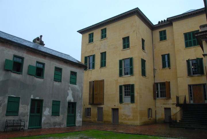 a large brick building with grass in front of a house