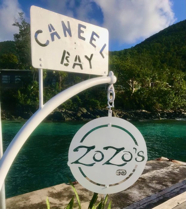 a close up of a sign in front of a body of water