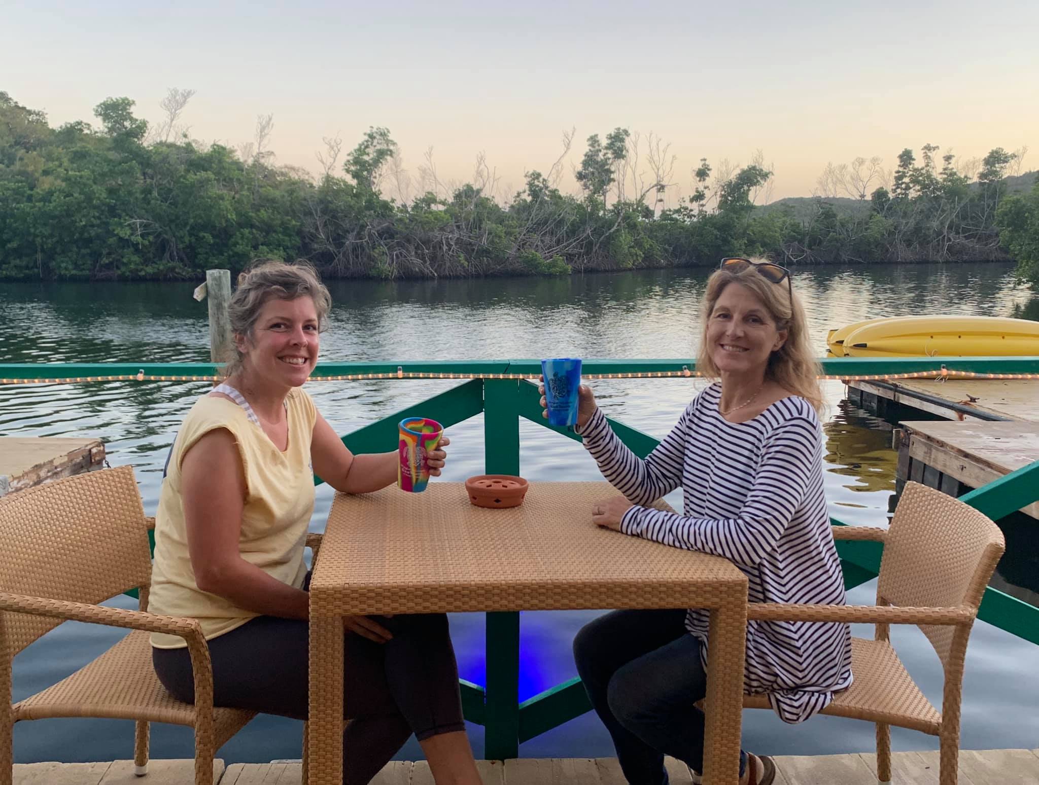 a group of people sitting at a table in front of a lake