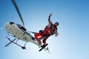 Skydiving tandem is jumping out of a helicopter