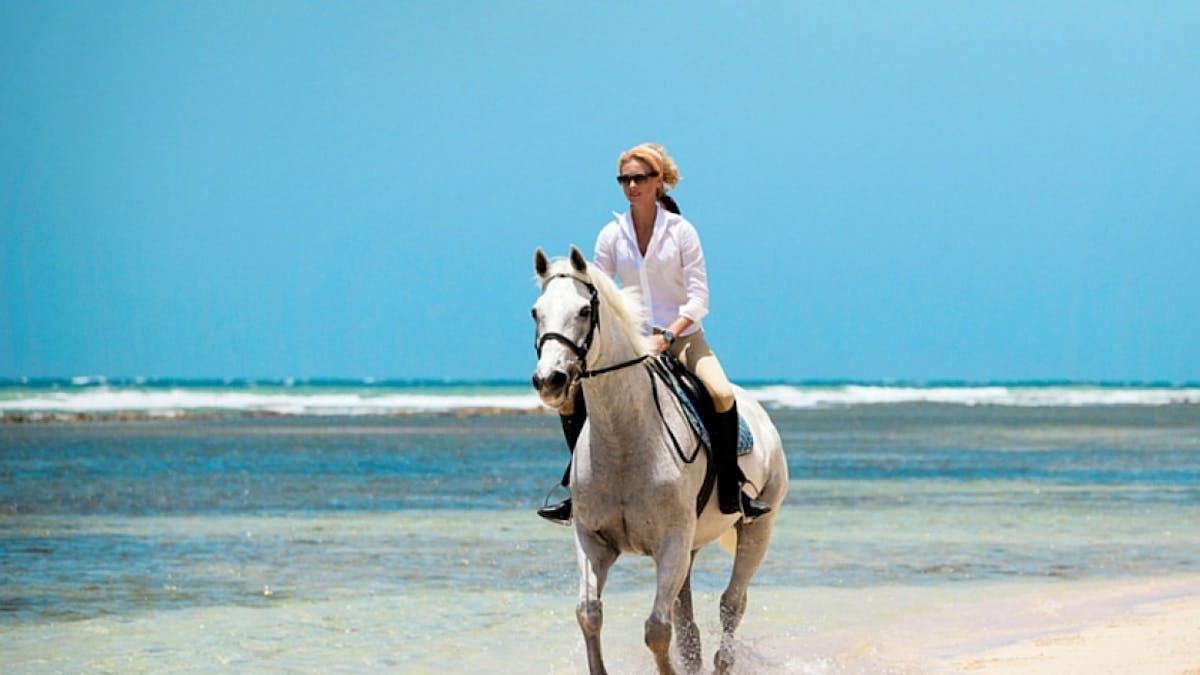 a man riding a horse on a beach