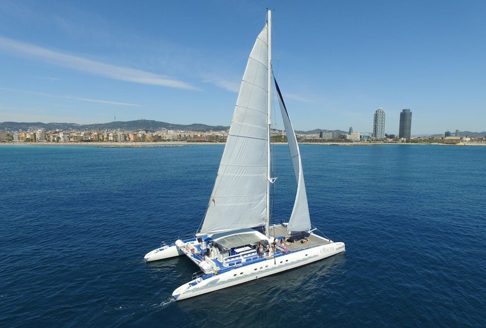 Orsom catamaran sailing in front of Barcelona