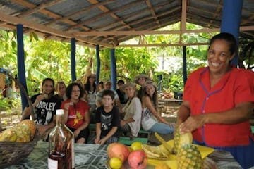 a group of people sitting at a fruit stand