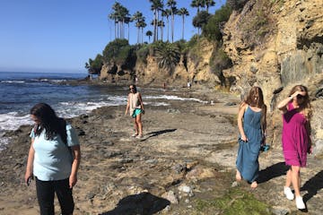 a group of people standing on a rocky beach