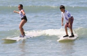 a young girl riding a wave on a surfboard in the ocean