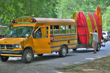 a yellow school bus parked in front of a car