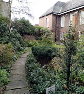 the garden of marshs library with a stone path