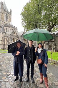 a group of people posing for a picture while holding an umbrella