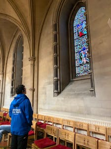 a person looking at the stained glass windows