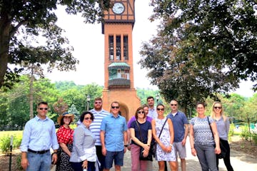 a group of people standing in front of a clock tower