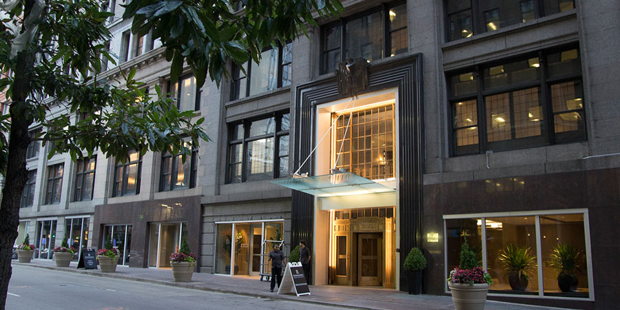 a large building with a clock on the side of a road