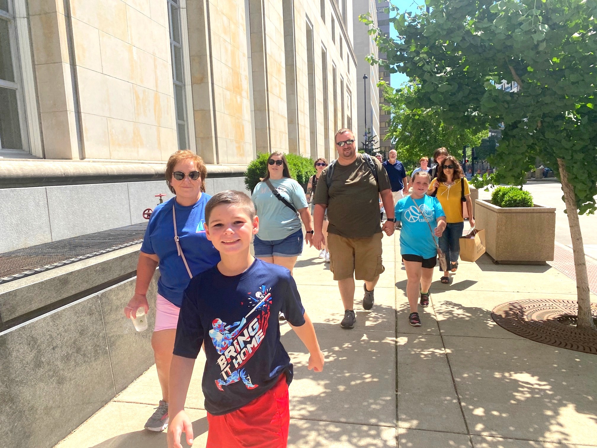 a group of people walking on a sidewalk