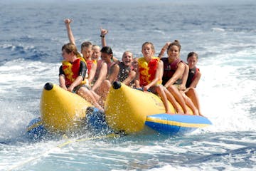a group of people riding on the back of a boat in the water