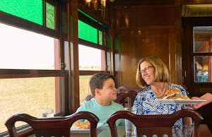 A woman and her son being served lunch on the Strasburg Rail Road dining car.