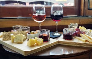 Two charcuterie boards and two glasses of wine on a table inside the dining car of the Strasburg Rail Road.