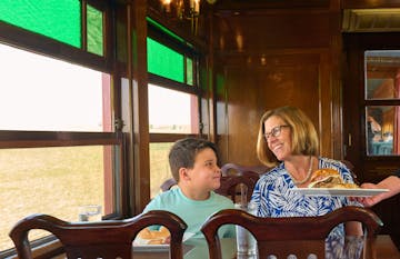 A woman and her son being served a meal on the Strasburg Rail Road dining car.