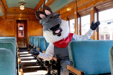 The Easter Bunny sitting in the seats on the empty coach car of the Strasburg Rail Road.