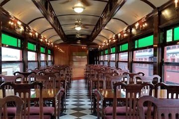 Empty tables and chairs lined up inside a historic dining car at the Strasburg Rail Road.