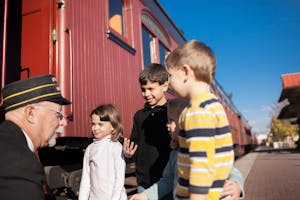 Four children meet with a conductor outside the Strasburg Rail Road train car at East Strasburg Station.