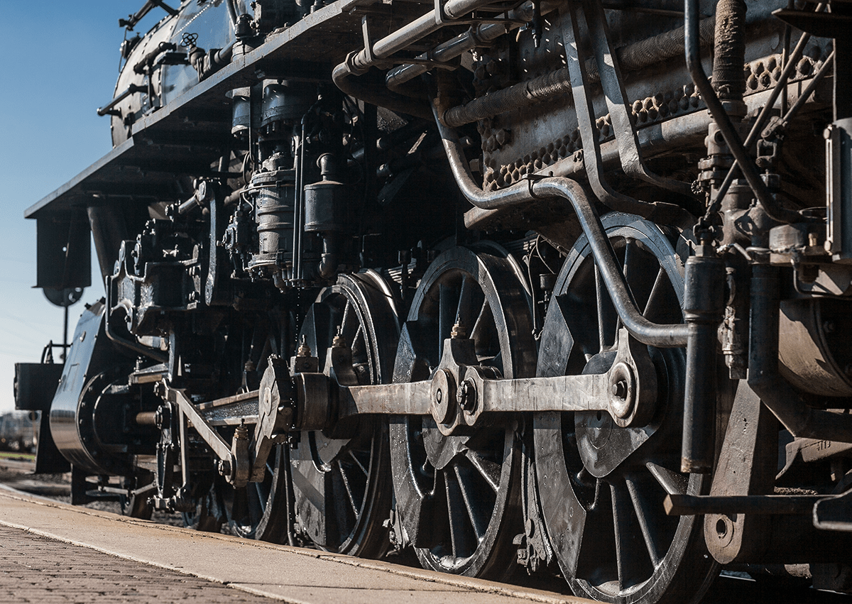 Close-up of three large driving wheels under a steam locomotive.