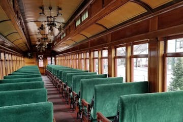 The inside of a train with rows of empty seats.