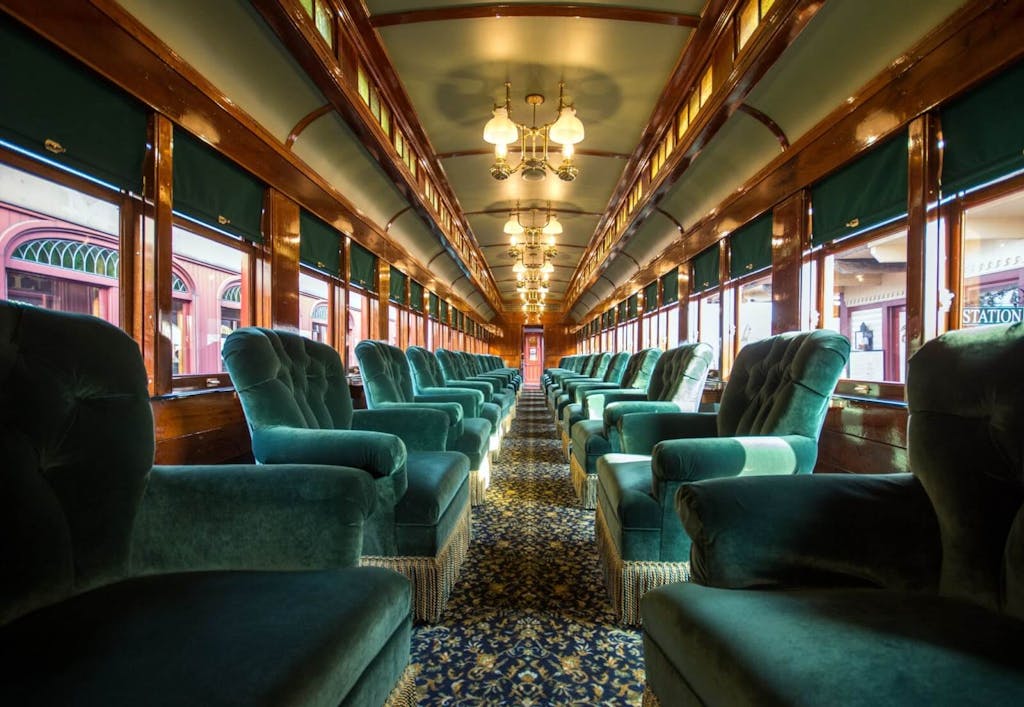 an upholstered train car with lines of chairs