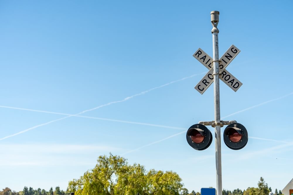 a railroad crossing sign on a pole with 2 spotlights