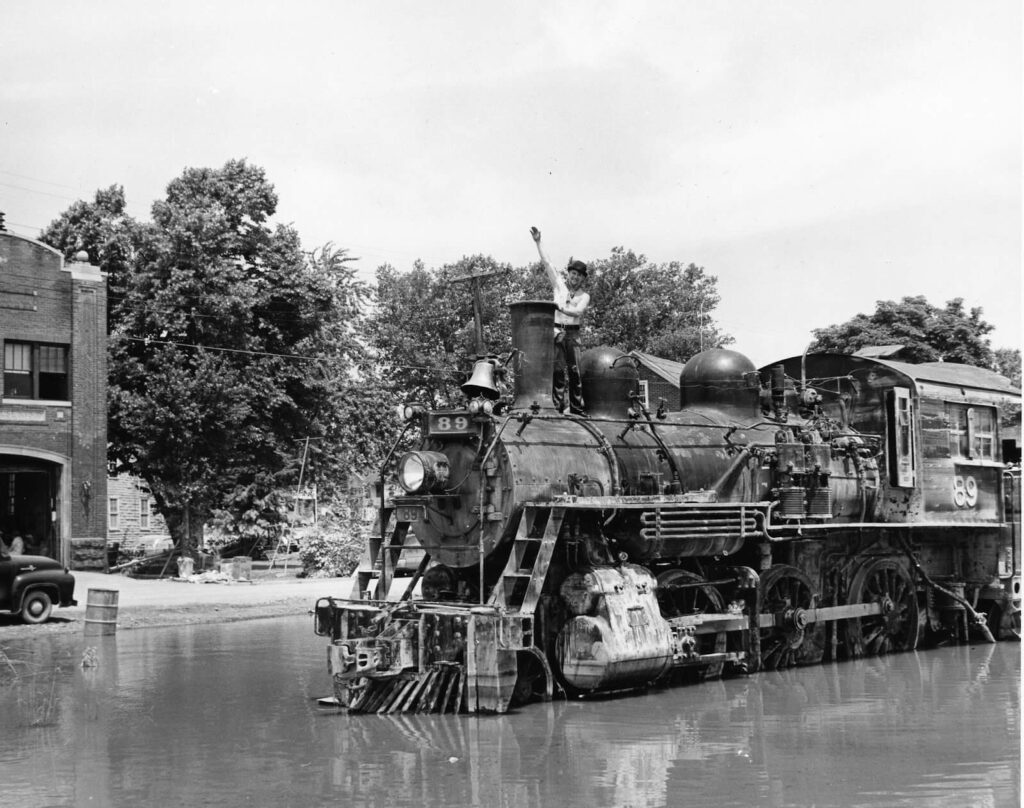 a vintage photo of engine 89 flooded on the train tracks after a storm