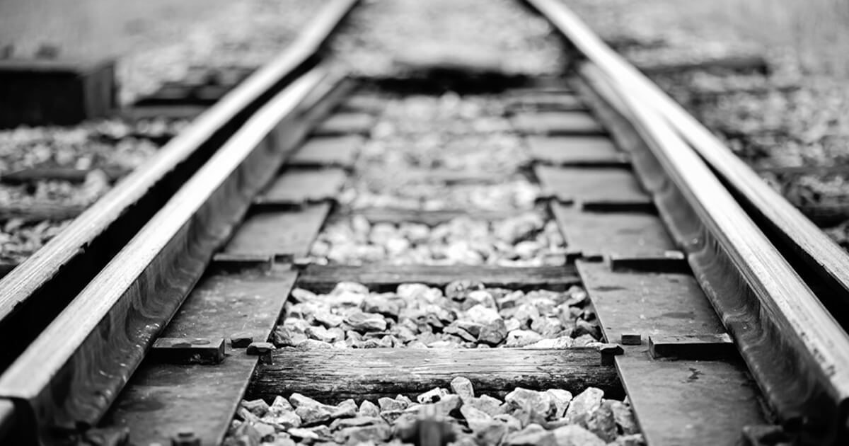 A black and white close up of railroad tracks.