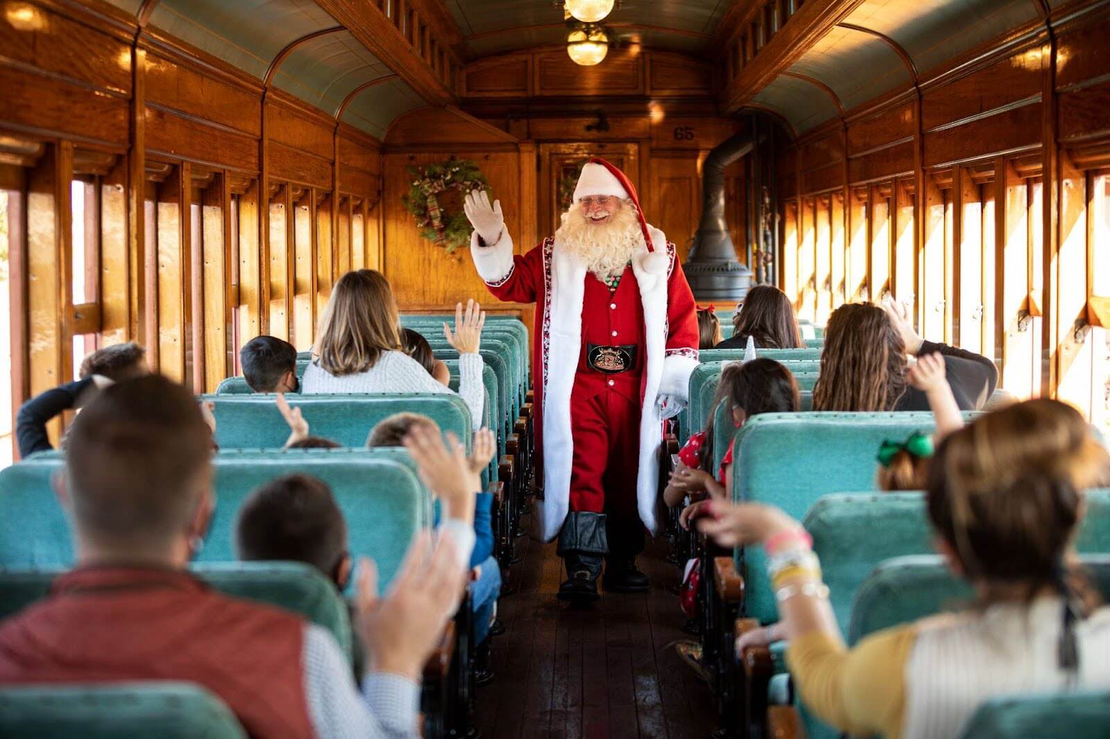 Santa waving to a train car full of families.