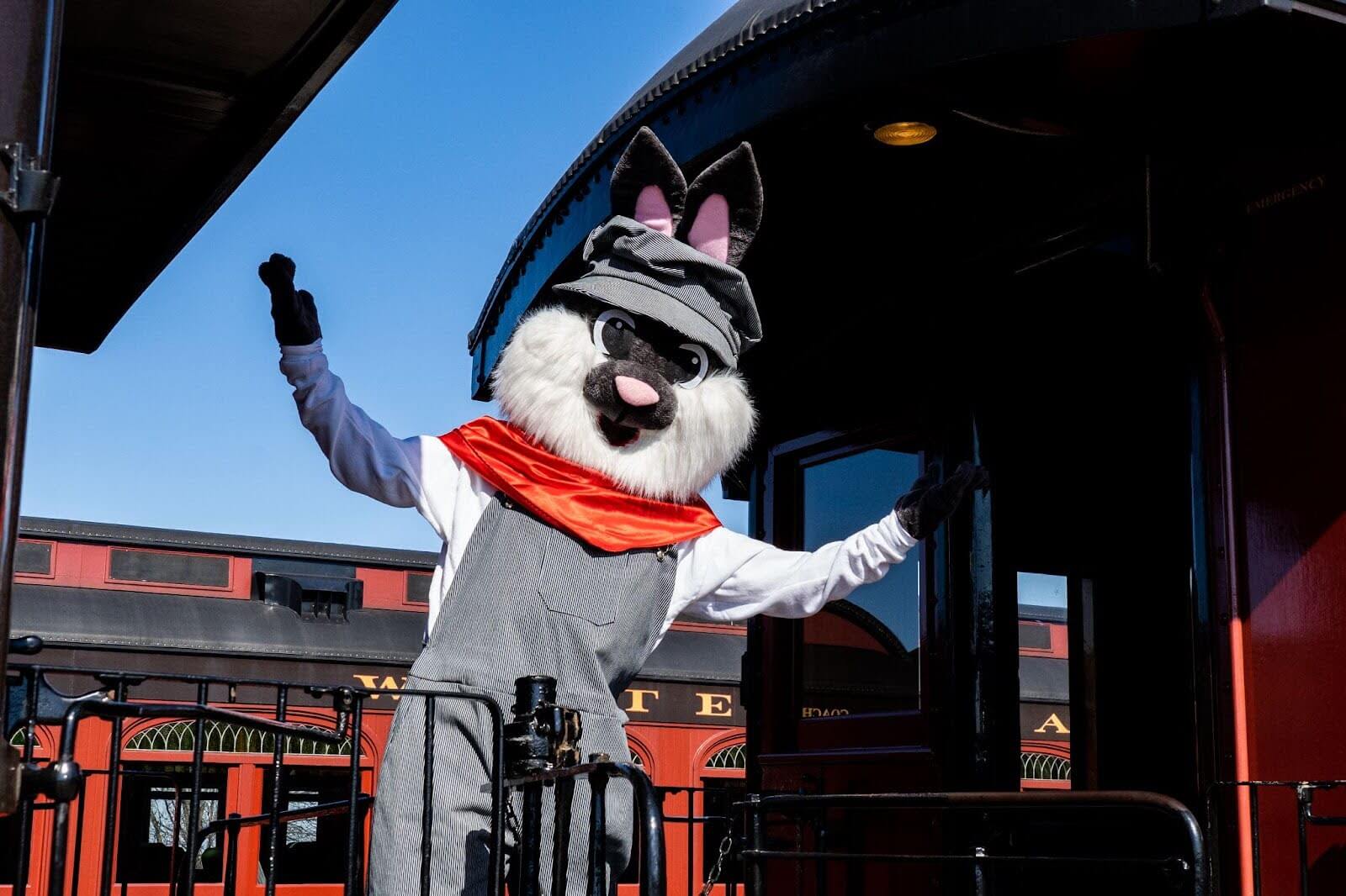 The easter bunny standing and waving from the caboose of the train.