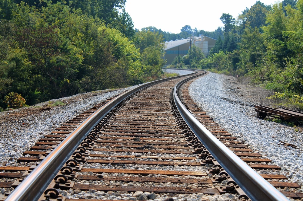 A closeup on railroad tracks near a forest.