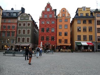 a group of people walking in front of Gamla stan