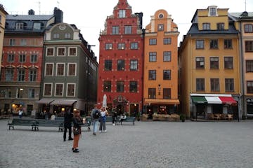 a group of people walking in front of Gamla stan