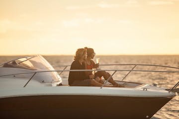A couple having a glass of champagne onboard watching Bora Bora sunset