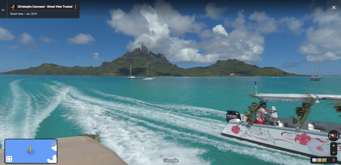 a small boat in a body of water with Bora Bora in the background