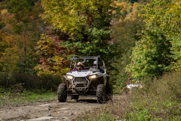 ATV driving down a mountain path with fall foliage